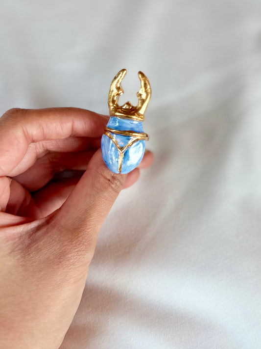 Ira handmade porcelain ring with blue centerpiece and elegant gold detailing